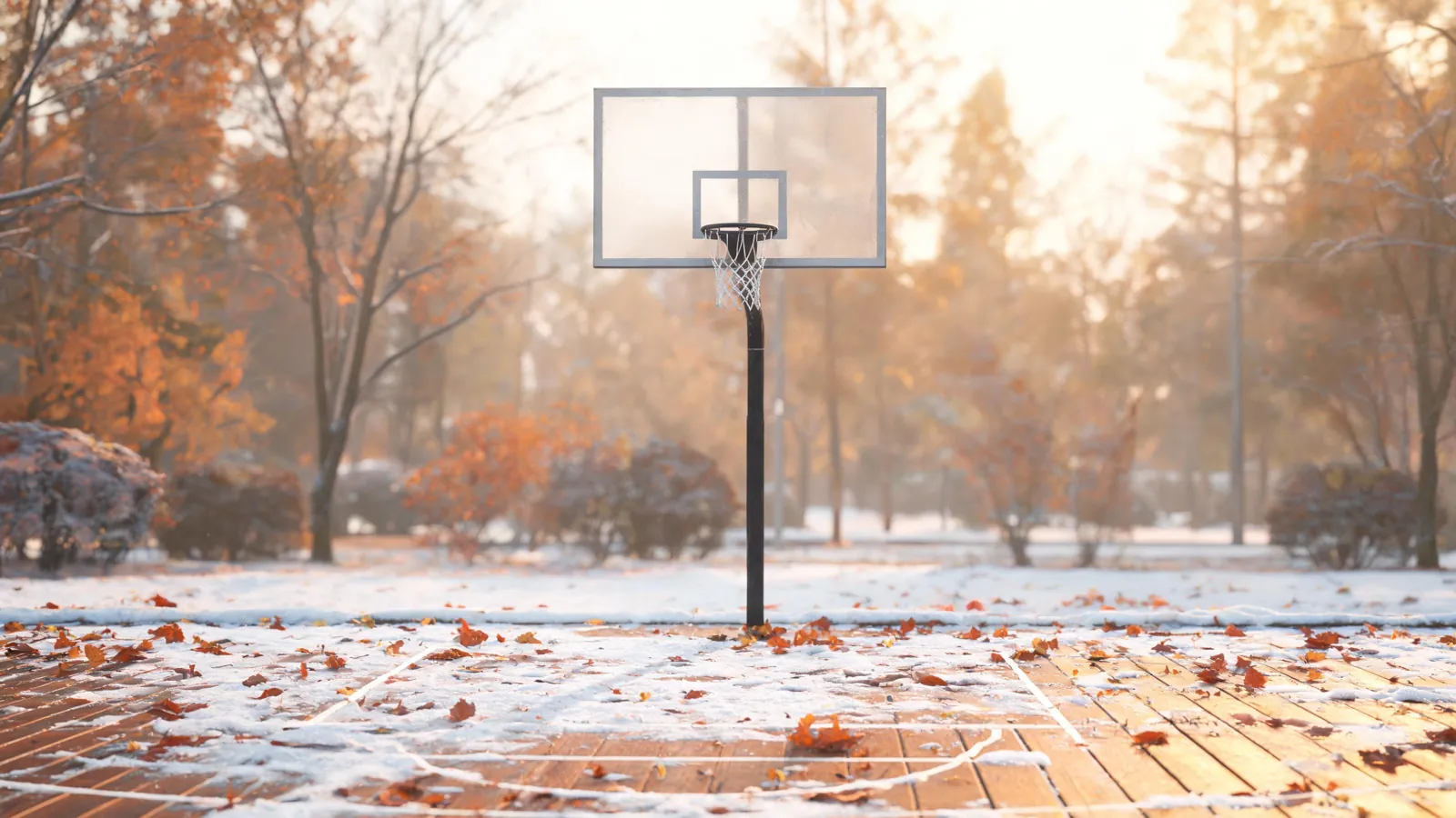 Utendørs basketballkurv med høstløv og første snø